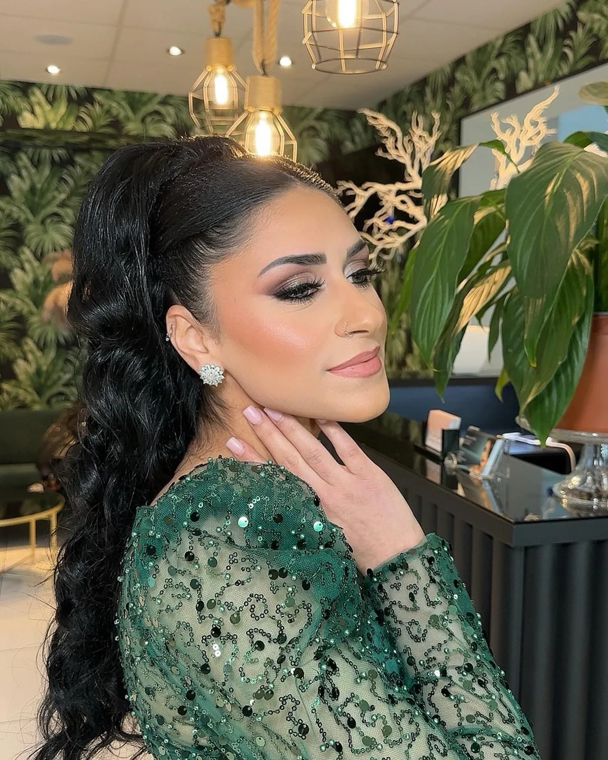 Der Make-up-Bereich mit Dschungeltapete, goldenen Käfigleuchten und schwarzem Tresen